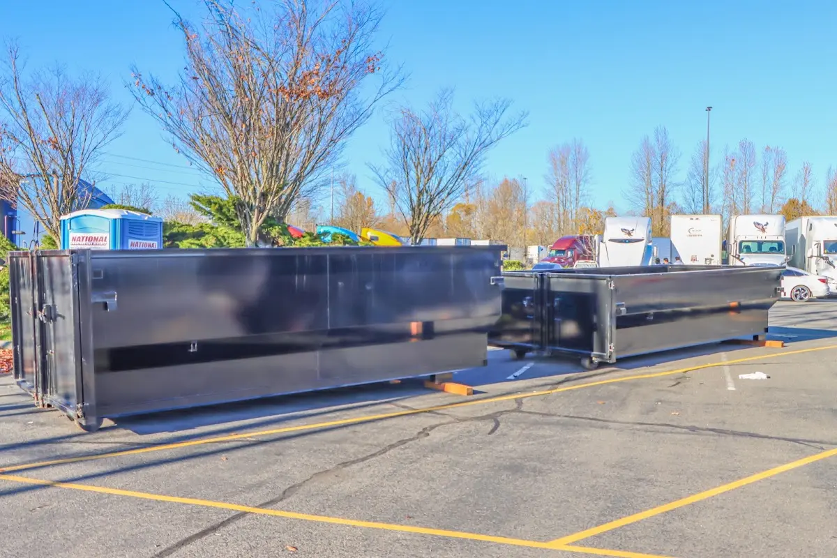 Professional dumpster rental service with roll-off container on residential driveway in East Greenbush